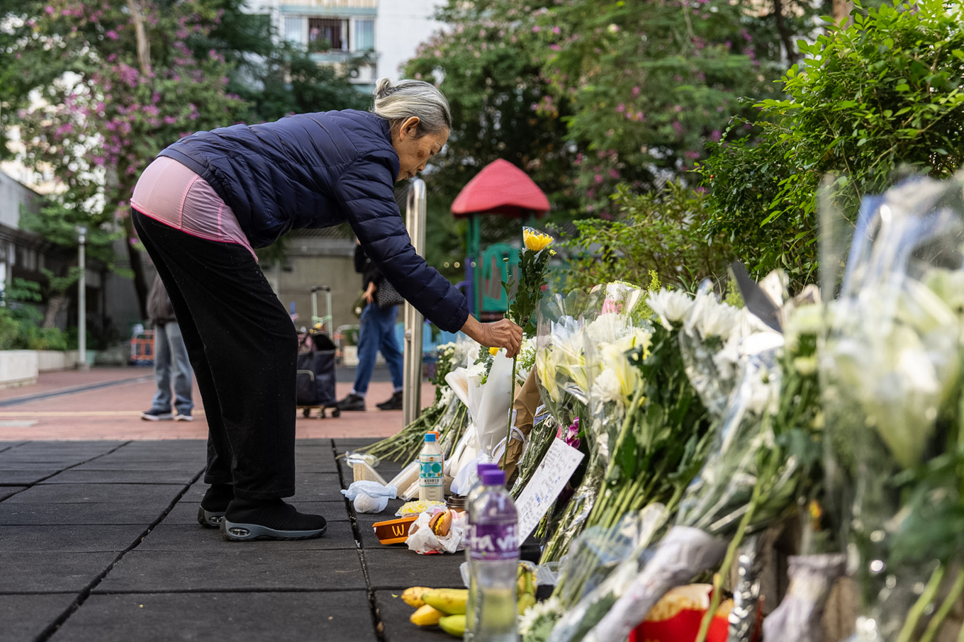 Bergen av blommor växer på de minnesplatser som anordnas efter branden i Wang Fuk Court. Foto: Chan Long Hei/AP/TT
