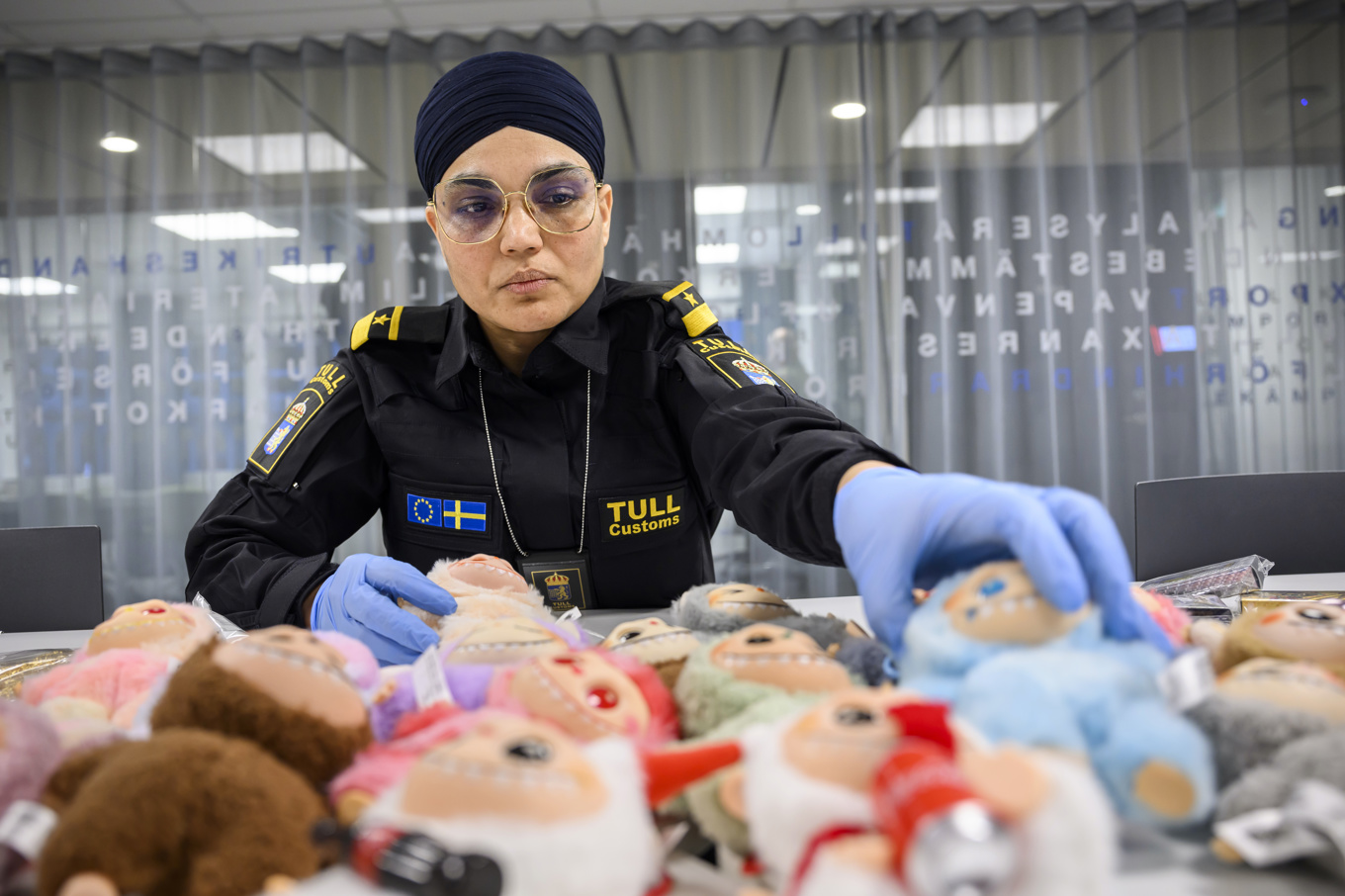 Sukhwinder Kaur och en hög med Lafufus (falska Labubus). Foto: Henrik Montgomery/TT