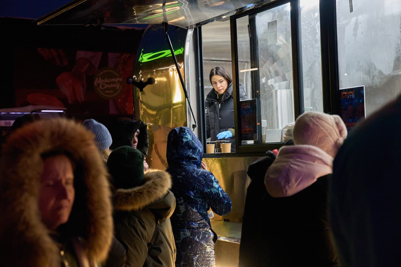 Invånare väntar på att få värmd mat serverad av Ukrainas militär i Kiev, där el- och värmebrist är akut för många boende. Foto: Efrem Lukatsky /AP/TT