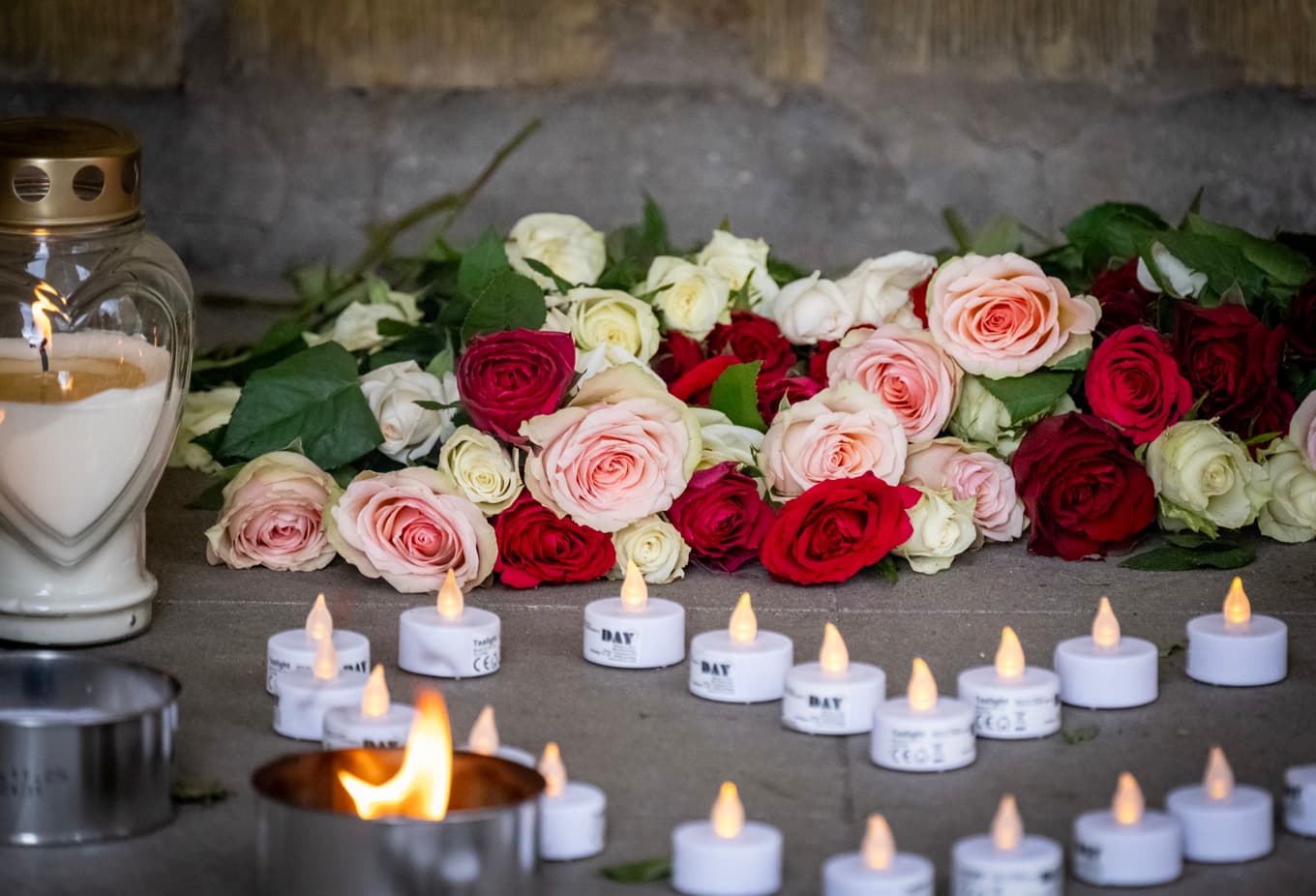 Ljus och blommor i porten efter att en 15-årig pojke sköts ihjäl i Rosengård i Malmö den 25 mars. Foto: Johan Nilsson/TT