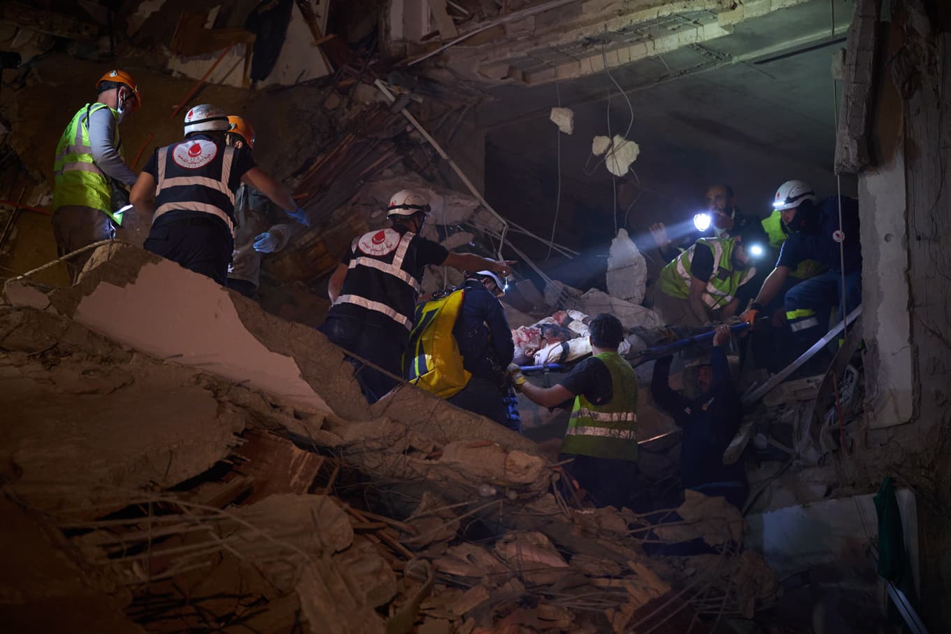 Räddningsarbetare för ut en skadad man från en byggnad i centrala Beirut som träffats i en israelisk flygattack. Foto: Emilio Morenatti/AP/TT
