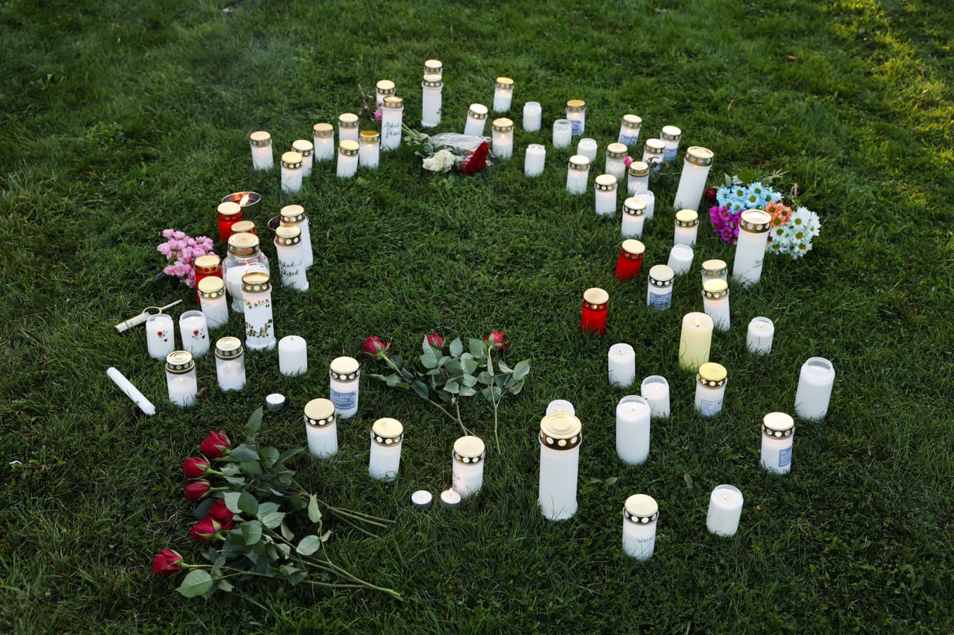 Blommor och ljus från en minnesstund i Hudiksvall efter mordet den 20 september förra året. Foto: Mats Andersson/TT