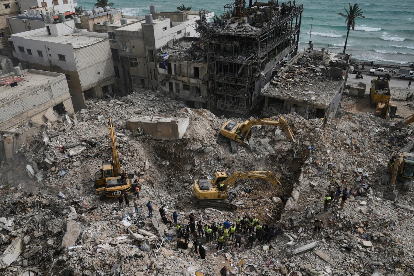 Grävmaskiner rensar bort spillror från byggnader som förstördes i israeliska luftanfall i staden Tyr på torsdagen. Foto: Bilal Hussein/AP/TT