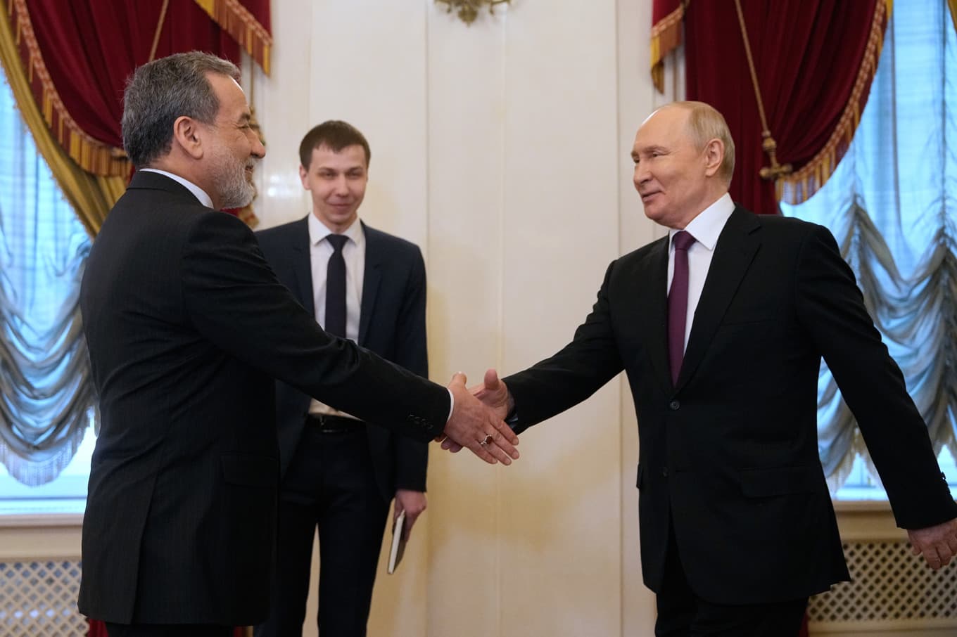 Abbas Araghchi och Vladimir Putin skakar hand i samband med måndagens möte, som hölls i Boris Jeltsins presidentbibliotek i S:t Petersburg. Foto: Dmitri Lovetsky, pool via AP/TT