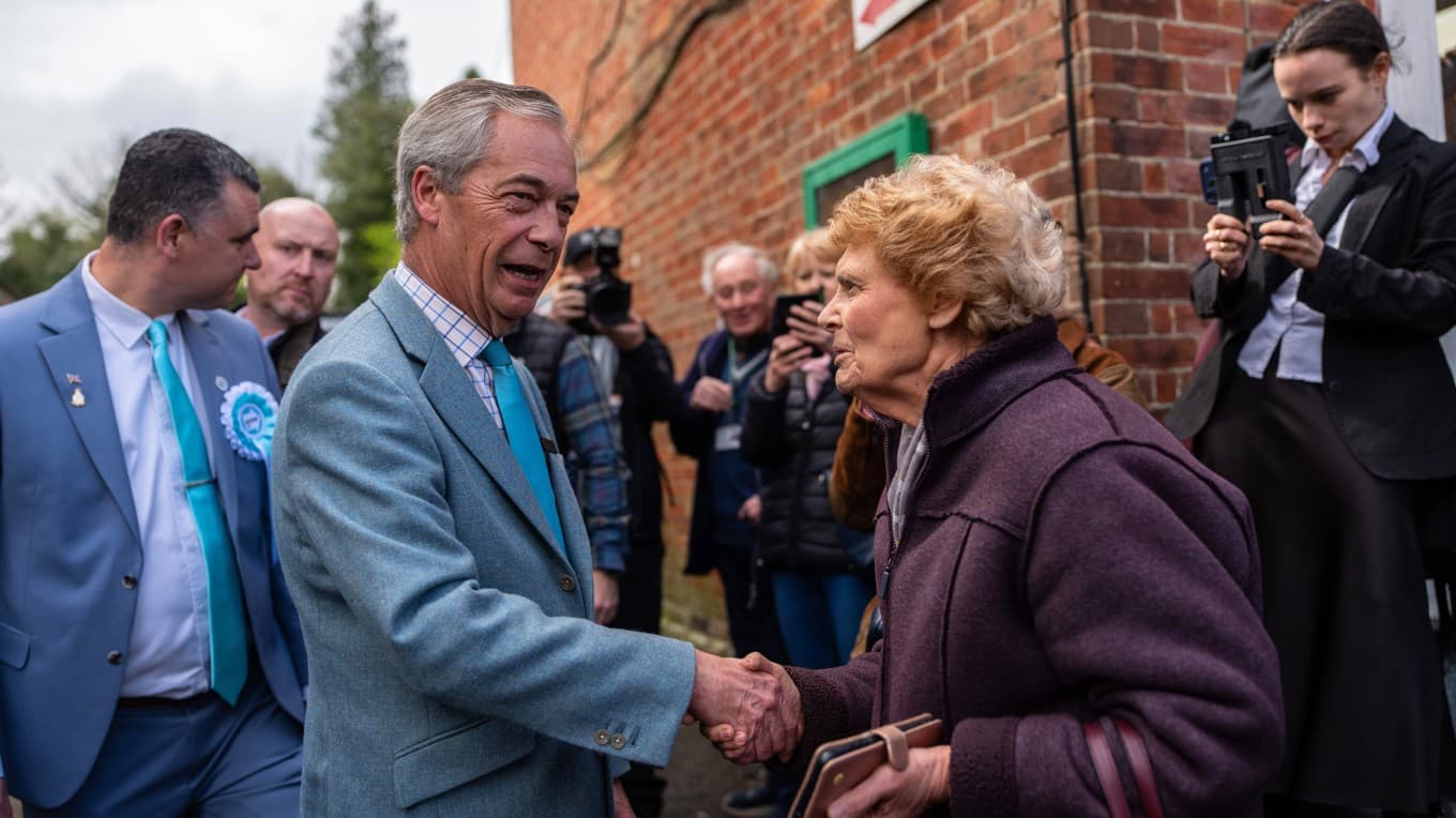 Reform UK:s ledare Nigel Farage hälsar på en anhängare under valkampanjen inför kommunalvalet den 7 maj i Crowborough i Storbritannien den 15 april. Foto: Carl Court/Getty Images
