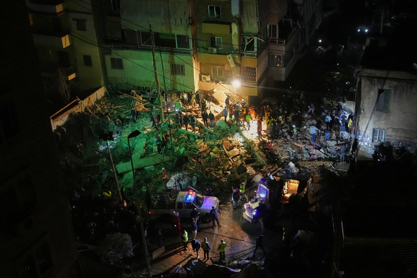 Räddningspersonal söker i rasmassorna efter den israeliska attacken i en förort i södra Beirut. Foto: Hassan Ammar/AP/TT