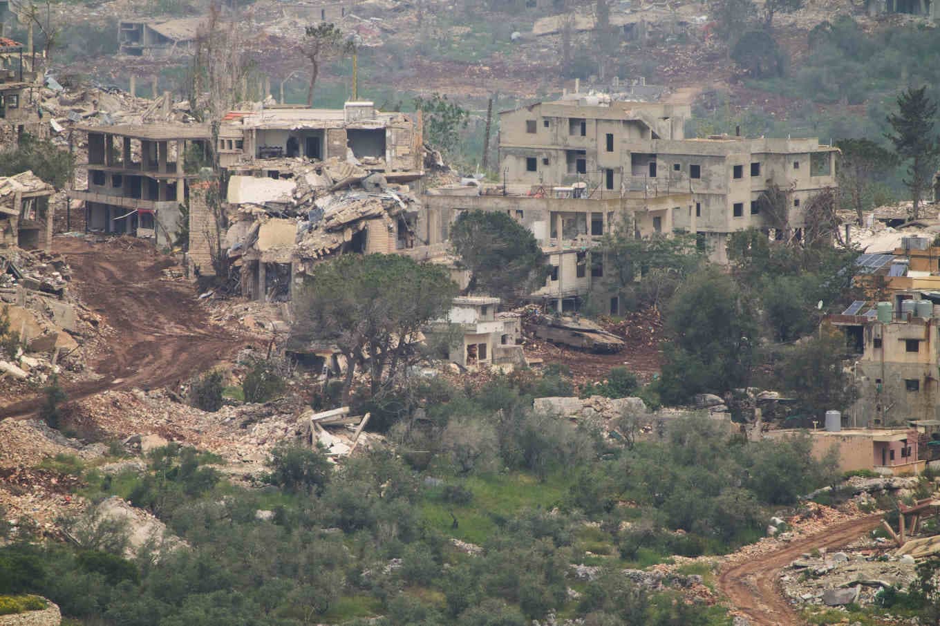 Israeliska militärfordon i en by i södra Libanon på tisdagen, sett från andra sidan gränsen i norra Israel. Foto: Ariel Schalit/AP/TT