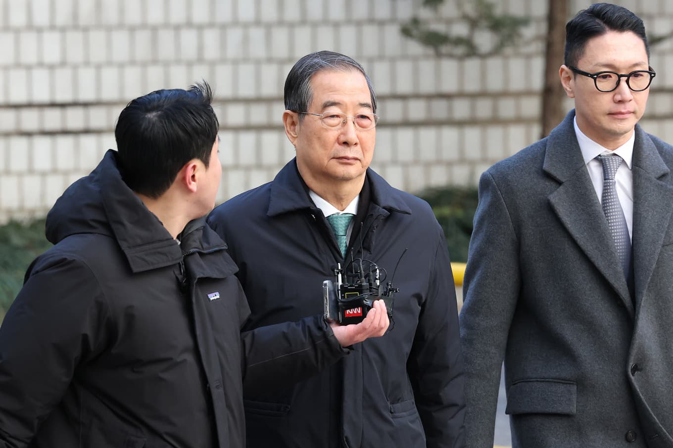 Han Duck-Soo, mitten, inför domstolsförhandlingarna i januari. Foto: Chung Sung-Jun/AP/TT