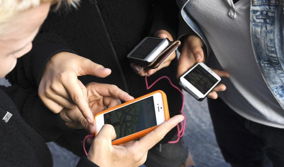 Barn med mobiler. Nu rekommenderas att barn under 13 år inte ska använda smarta telefoner. Foto: Fredrik Sandberg/TT