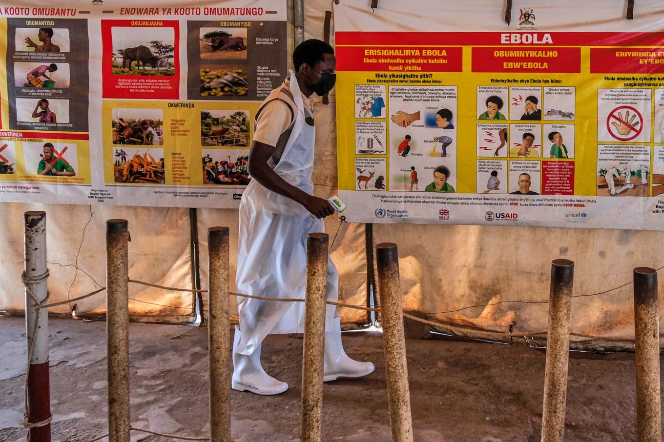 En hälsoarbetare går förbi en informationsplansch om blödarfebern ebola på en tillfällig hälsomottagning i Mpondwe, vid gränsen mellan Kongo-Kinshasa och Uganda. Bild från i torsdags. Foto: Hajarah Nalwadda /AP/TT