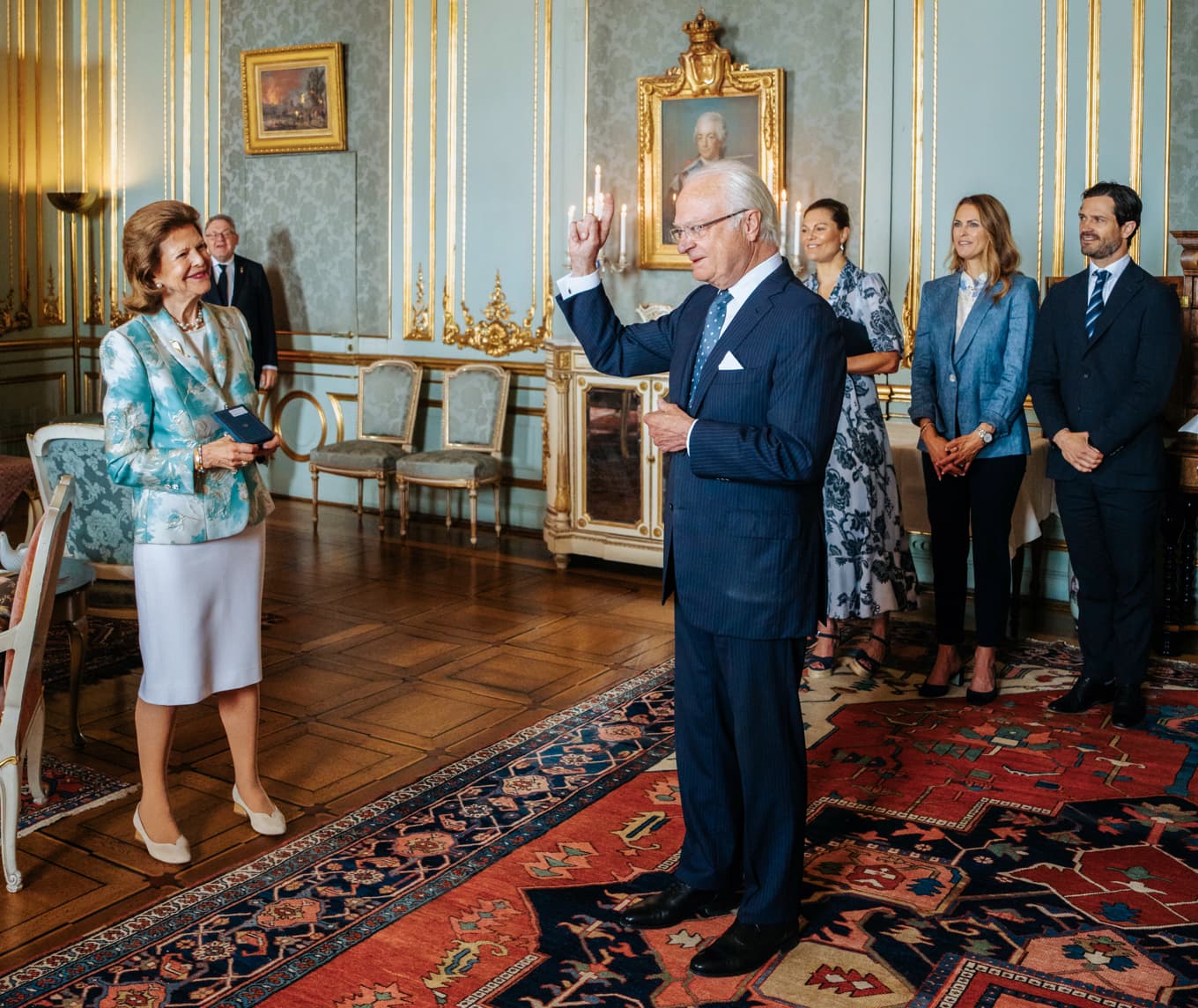 Kung Carl XVI Gustaf delar ut Serafimermedaljen till drottning Silvia vid en ceremoni på Stockholms slott inför kungaparets guldbröllopsdag. Foto: Clement Morin/Kungliga Hovstaterna