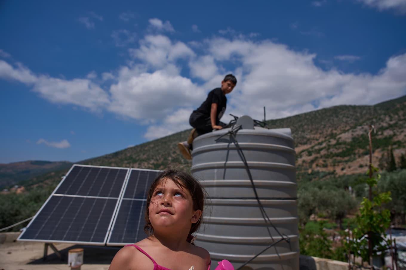 Spänt läge i södra Libanon. På denna bild från i fredags kontrollerar några barn familjens vattentank i Halta, nära israeliska gränsen. Foto: Hassan Ammar/AP/TT