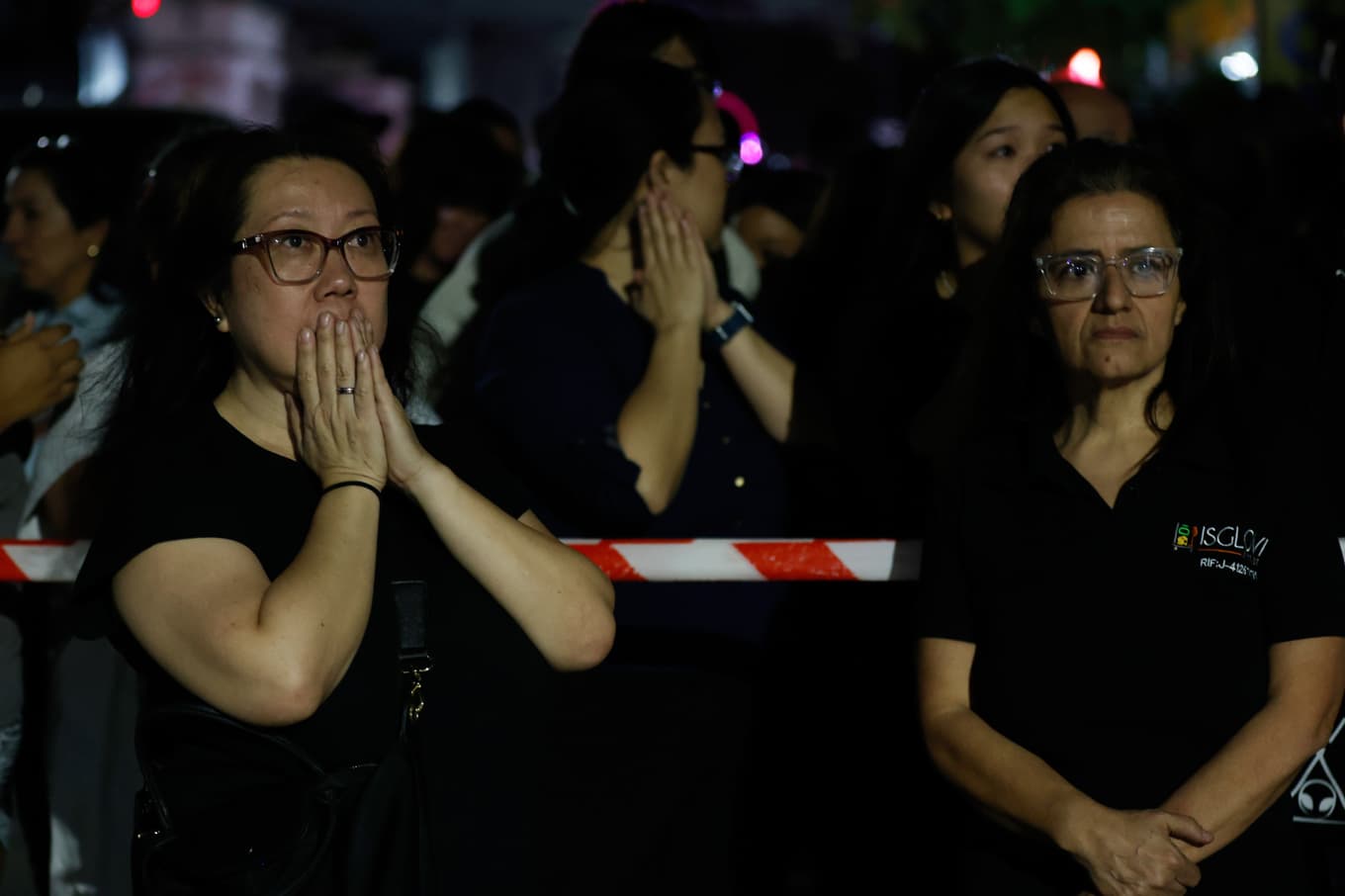 Skräckslagna invånare vid avspärrningar runt en raserad byggnad i Caracas efter skalven. Foto: Pedro Mattey/AP/TT