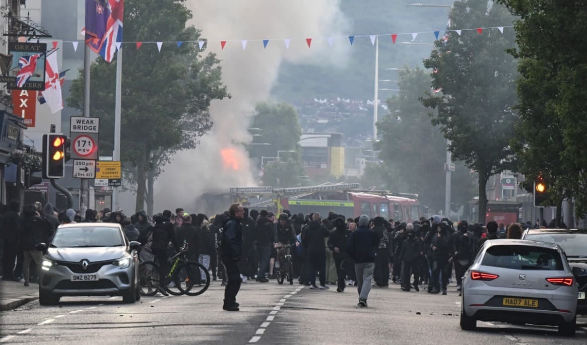 Polis och brandkår rycker ut efter att demonstranter satt eld på en buss på Newtownards Road i Belfast den 9 juni. Foto: Charles McQuillan/Getty Images