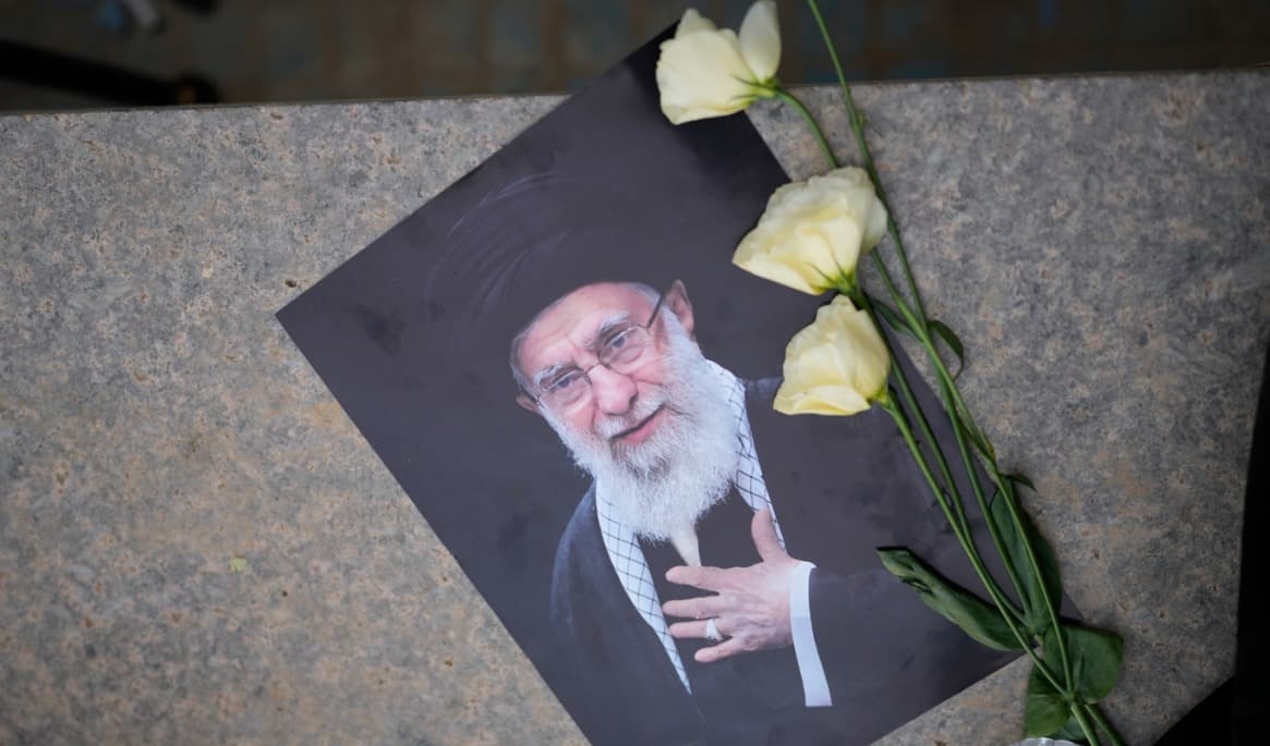Rosor på ett porträtt av Irans tidigare högste ledare Ali Khamenei på lördagen. Foto: Altaf Qadri /AP/TT