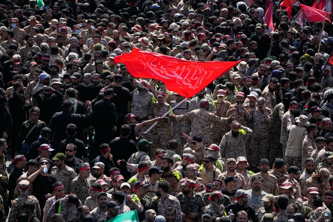 Revolutionsgardister med flaggor i de folkmassor som samlats i Teheran vid begravningsceremonierna för Ali Khamenei. Foto: Vahid Salemi/AP/TT