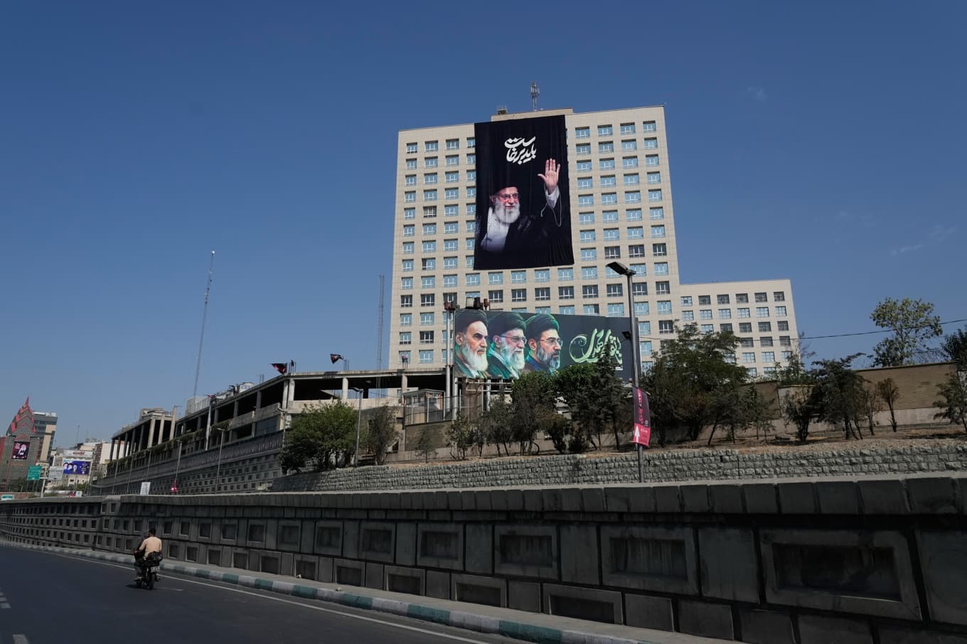 En affisch på ayatollah Ali Khamenei, som dödades i början av kriget, hänger på en byggnad i Teheran. Foto: Vahid Salemi /AP/TT