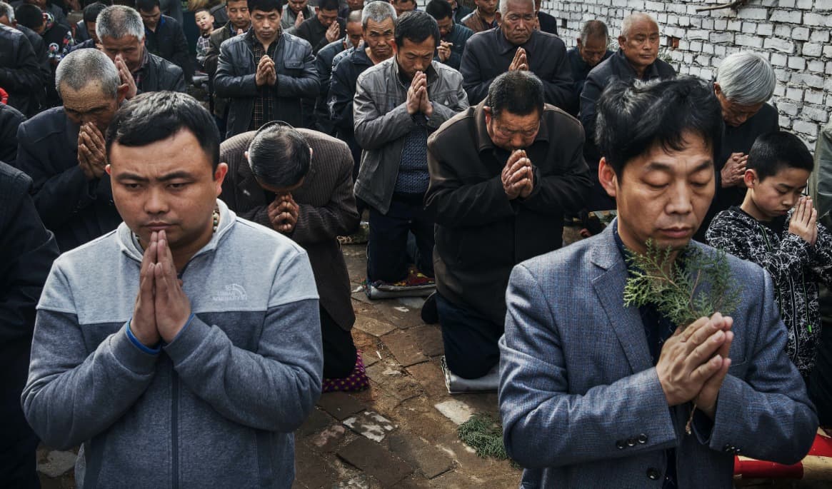 Kinesiska katoliker i Shijiazhuang i Hebeiprovinsen ber under palmsöndagen. De är medlemmar av en inofficiell kyrka, som alltså inte står under den partistyrda föreningens kontroll. Foto: Kevin Frayer/Getty Images