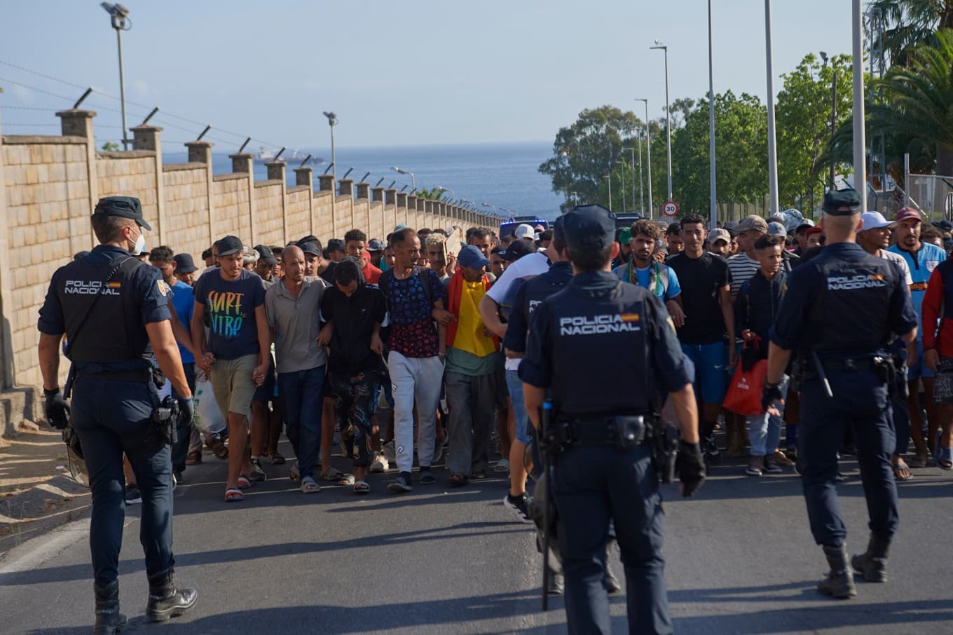 Migranter eskorteras till tillfälliga förvar i Ceuta av spansk polis på torsdagen. Foto: Antonio Sempere/AP/TT