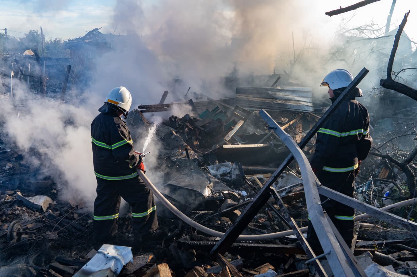 Räddningsarbetare släcker en husbrand efter ett ryskt anfall mot Charkiv på fredagen. Foto: Andrii Marienko/AP/TT