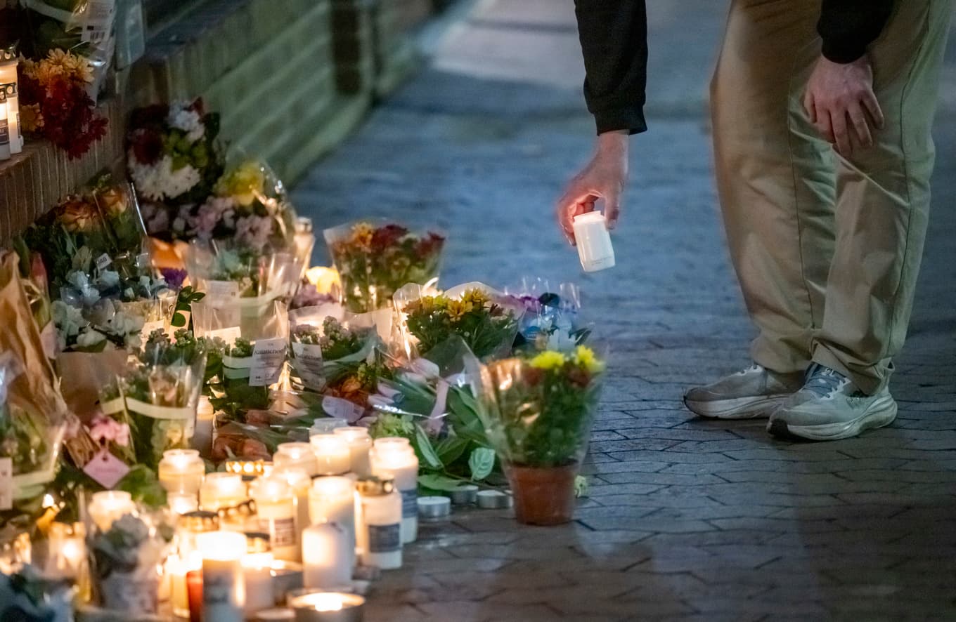 En minnesplats med blommor och ljus har vuxit fram på mordplatsen i Bellevuegården i Malmö. Foto: Johan Nilsson/TT