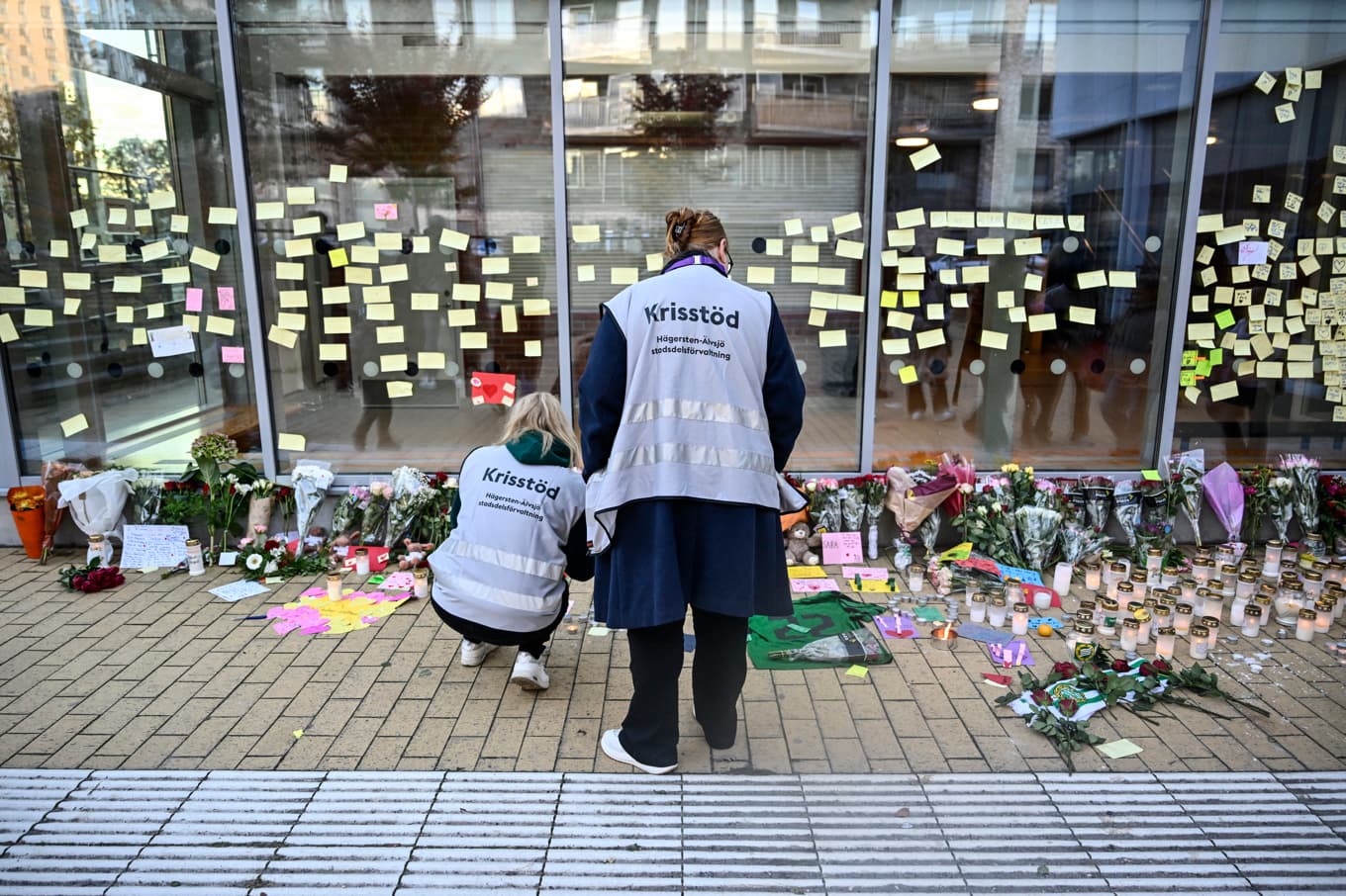 Sörjande har lämnat blommor och ljus utanför Kämpetorpshallen i Solberga, Älvsjö, där en 24-årig kvinna blev skjuten på fredagskvällen och senare avled. Foto: Pontus Lundahl/TT