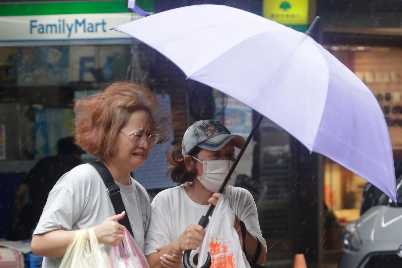 Två kvinnor kämpar mot vindarna i Taipei på fredagen. Foto: Chiang Ying-ying/AP/TT