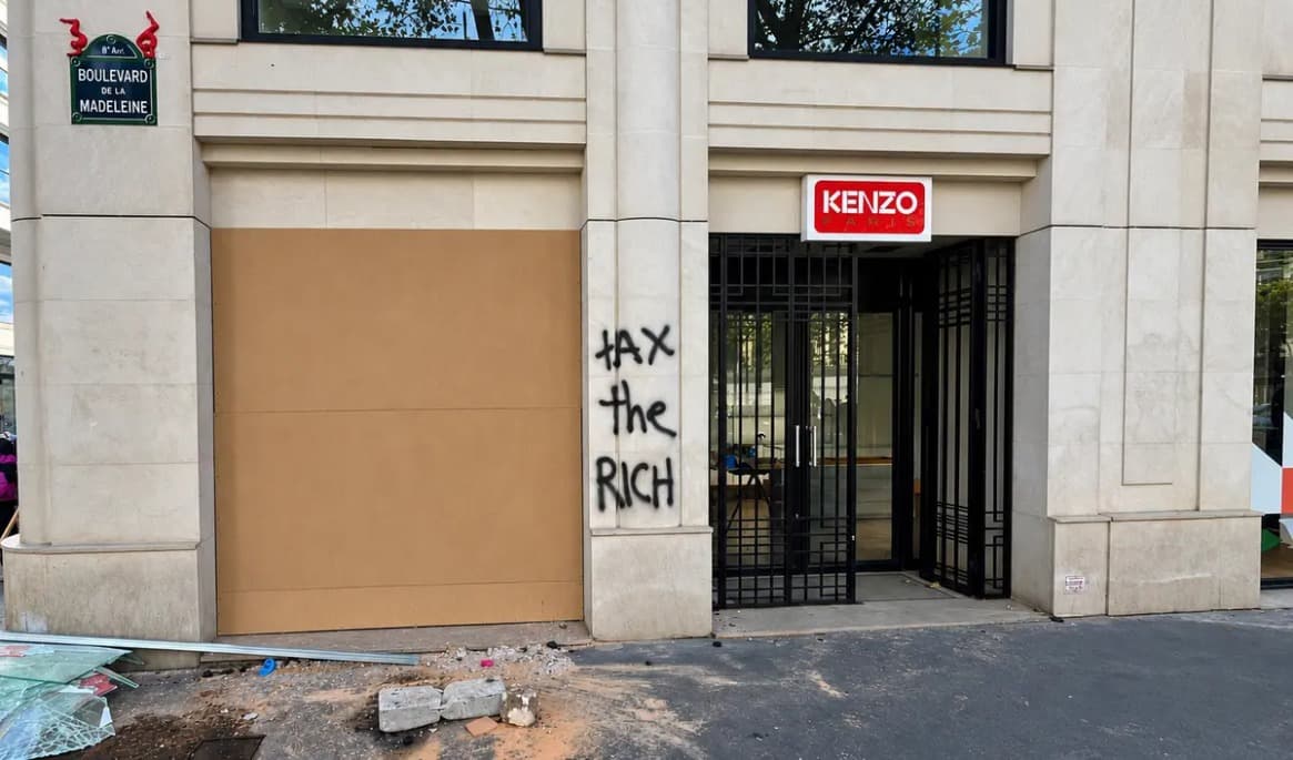 Ett igenspikat fönster, krossat glas och klotter utanför franska lyxmärket Kenzos butik på Boulevard de la Madeleine i Paris den 18 oktober. Foto: Etienne Fauchaire