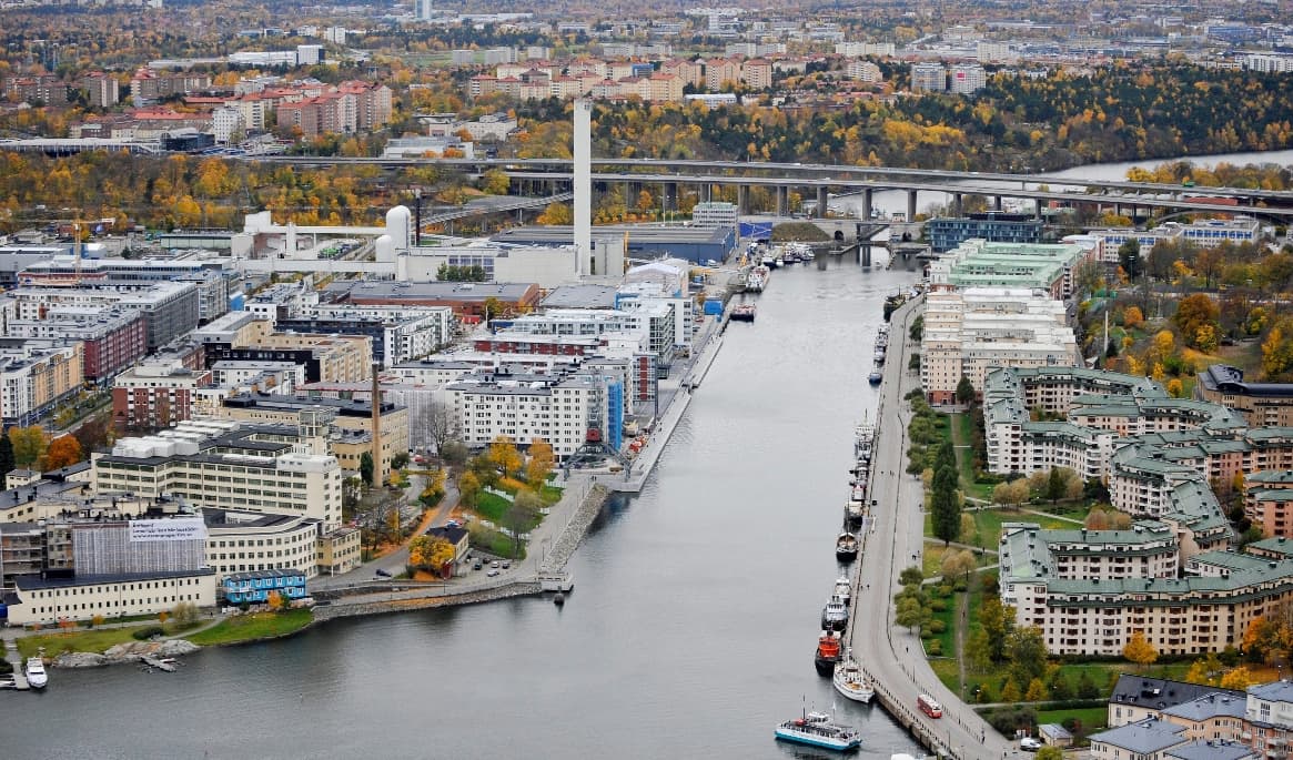 Tunnelbanestationen Hammarby Kanal kommer ligga under Hammarbykanalen med en uppgång i Hammarby sjöstad (t.v i mitten) och en på Södermalm under Hamnvakten 7 (till höger på bilden) Foto: Bertil Ericson / SCANPIX via TT