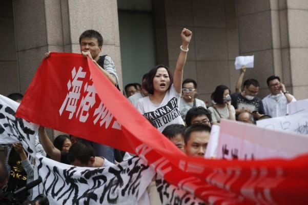 
Invånare i Tianjin protesterar utanför det hotell där myndigheterna höll presskonferens i Tianjin den 17 augusti 2015. Foto: STR/AFP/Getty Images                                            