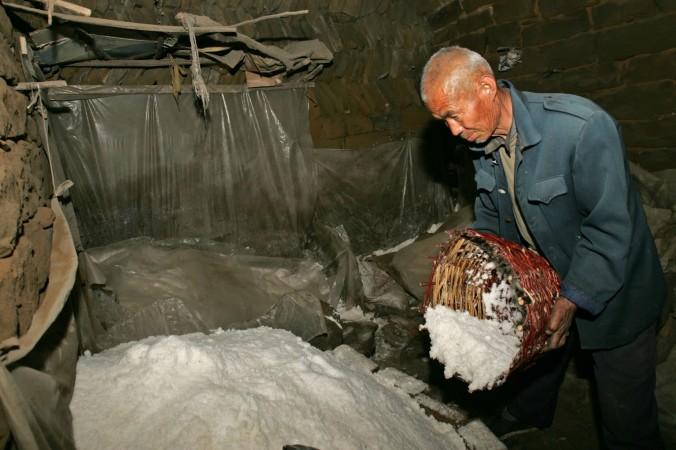 En kinesisk bonde i Shaanxiprovinsen (som inte har något med verksamheten i artikeln att göra) häller salt på hög. I Kina säljer ligor giftigt industriellt salt som bordssalt, en verksamhet som är svår att komma åt på grund av dålig lagstiftning. (Foto: China Photos/Getty Images)