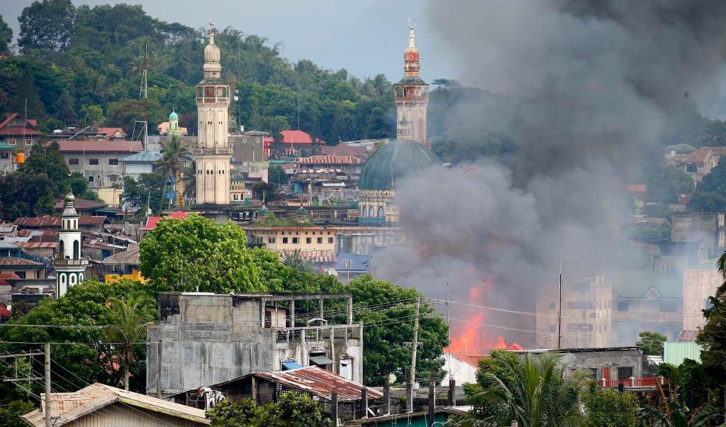 En byggnad i Marawi har fattat eld efter flygräder av det filippinska flygvapnet. Foto: Bullit Marquez/AP/TT