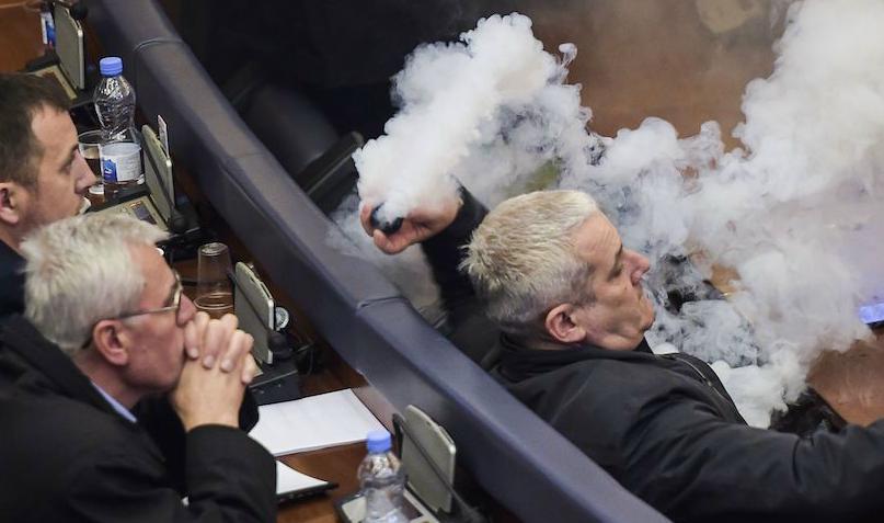 


En oppositionspolitiker i Kosovo kastar en tårgasbehållare under parlamentets session den 21 mars 2018. Foto: Armend Nimani/AFP/Getty Images                                                                                                                                    