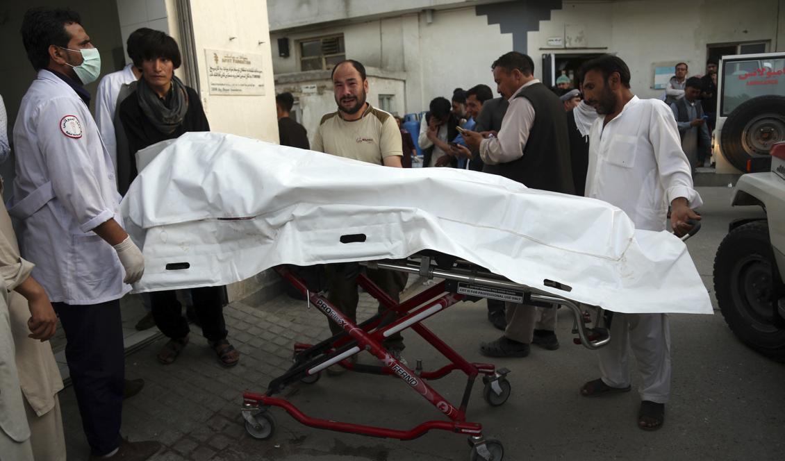 Afghanska sjukvårdare för i väg ett av dödsoffren i onsdagens attentat. Foto: Rahmat Gul/AP/TT