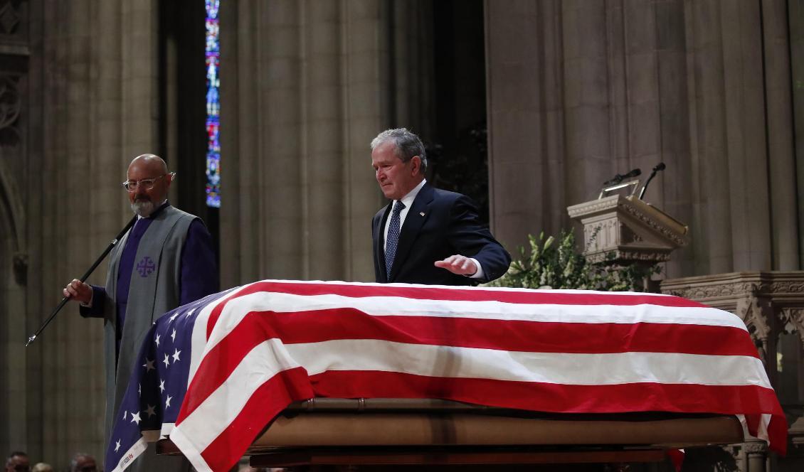 George W Bush klappade sin fars kista lätt efter ett tal under statsbegravningen i Washington på onsdagen. Foto: Alex Brandon/AP/TT