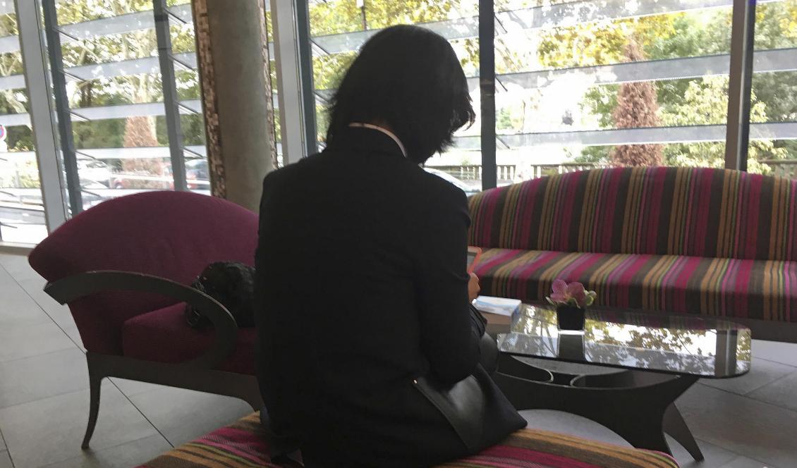 Grace Meng, som inte vill visa sitt ansikte, skyddas numera av polis efter försök att föra bort henne. Foto: John Leicester/AP/TT