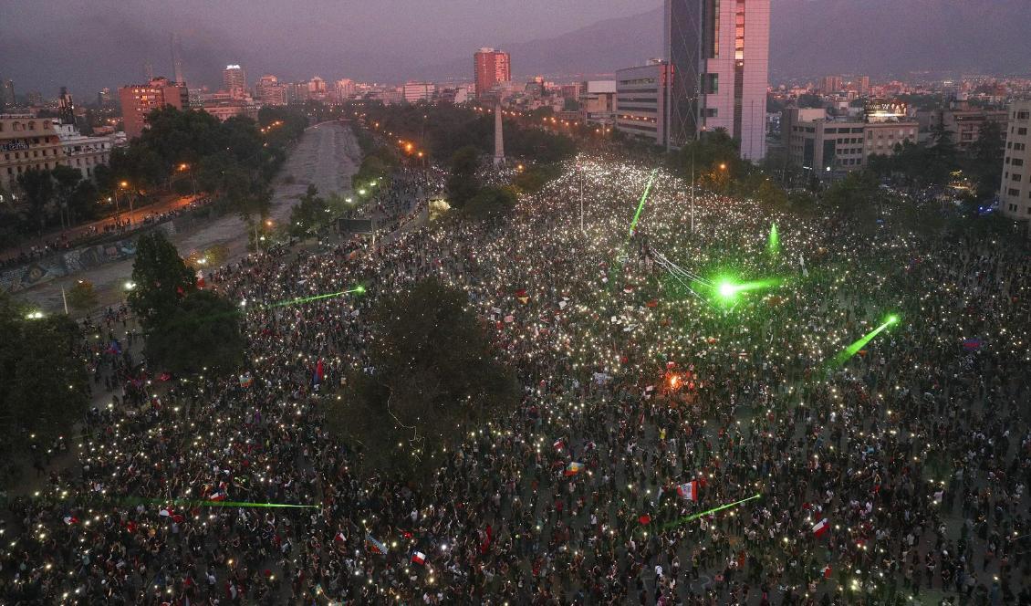 Tiotusentals demonstranter samlades vid Plaza Italia i Santiago på fredagskvällen. Foto: Esteban Felix/AP/TT