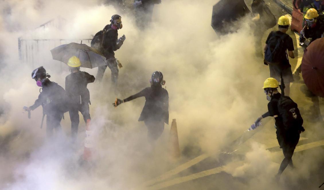 Demonstranter i polisens tårgas under en demonstration i Causeway Bay i Hongkong på söndagen. Foto: Vincent Thian/AP/TT