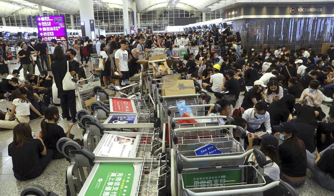 Demonstranter använder bagagevagnar för att hindra resenärer från att nå sina gater på Hongkongs flygplats. Foto: Vincent Yu/AP/TT