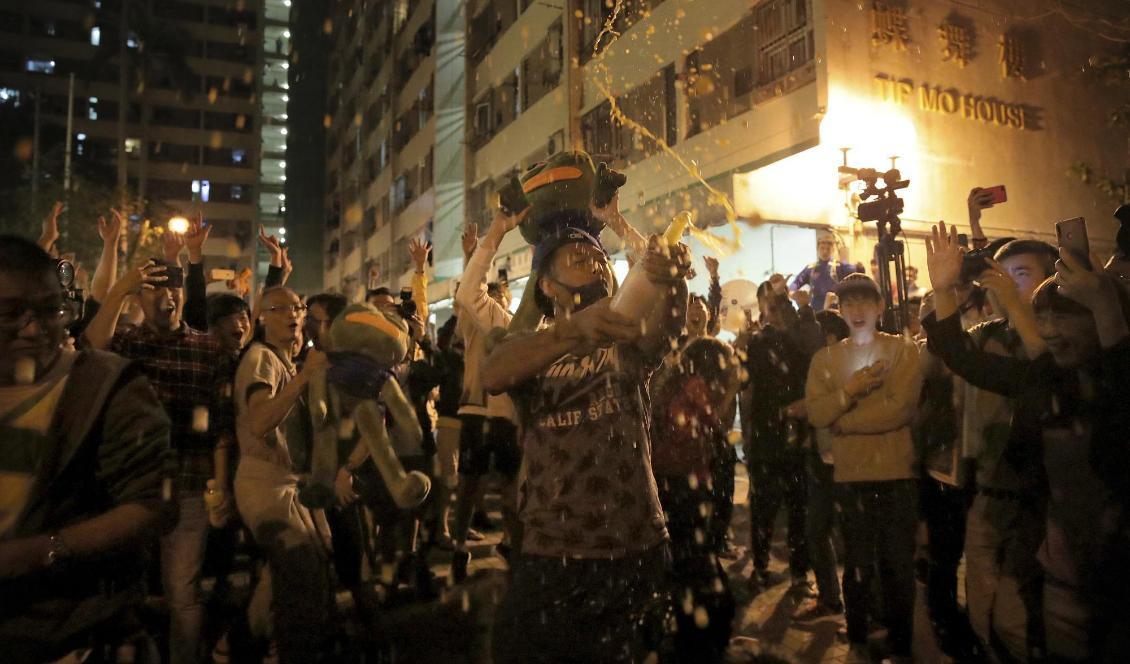 Demokratiaktivister firar framgångarna natten till måndagen. Foto: Kin Cheung/AP/TT