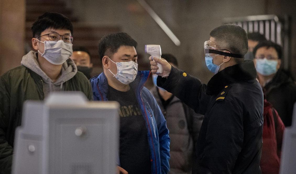 En kinesisk resenär genomgår hälsokontroll i Pekings järnvägsstation den 23 januari. Foto: Kevin Frayer/Getty Images