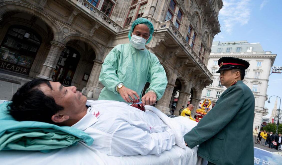 Falun Gong-utövare utför en iscensättning av den kinesiska regimens organstöld på samvetsfångar vid en demonstration i Wien, Österrike den 1 oktober, 2018. Foto: Joe Klamar, AFP via Getty Images.
