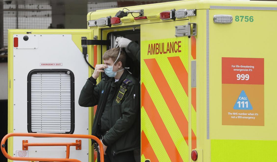
En vårdanställd får hjälp av en kollega att få på sig ett munskydd, vid ett sjukhus i London. Foto: Kirsty Wigglesworth/AP/TT                                                