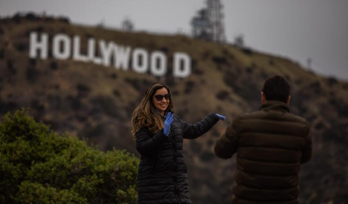 



En kvinna poserar nedanför Hollywoodskylten i Kalifornien, den 22 mars 2020. Foto: Apu Gomes/AFP via Getty Images                                                                                                                                                                                                