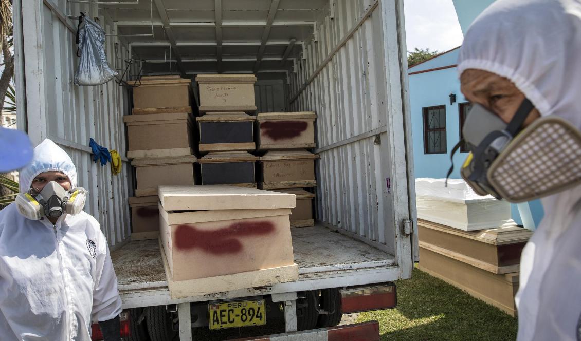 Begravningsarbetare lastar ur kistor med kvarlevorna av personer som misstänks ha avlidit i sviterna av det nya coronaviruset i Perus huvudstad Lima. Foto: Rodrigo Abd/AP/TT