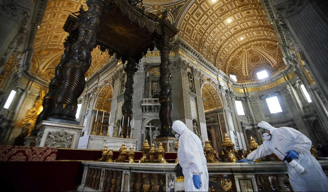 Arbetare i skyddsdräkter sanerar Peterskyrkan i Rom inför öppnandet på måndag. Foto: Andrew Medichini/AP/TT