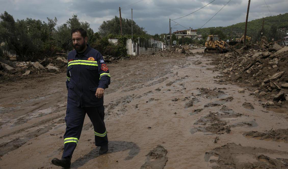 
En räddningsarbetare går på en förstörd väg i byn Politiká som drabbats hårt av regnet. Foto: Yorgos KarahalisAP/TT                                            