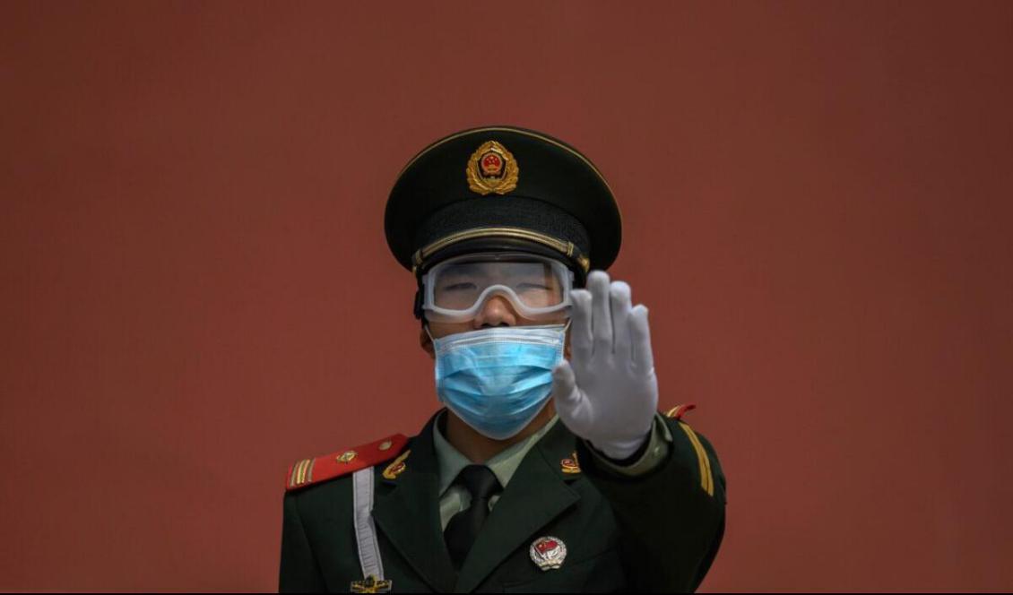 

En kinesisk paramilitärpolis står vakt utanför ingången till den förbjudna staden i samband med att den åter öppnades för en begränsad allmänhet efter nedstängning på grund av covid-19-pandemin. Peking, Kina den 1 maj 2020. Foto: Kevin Frayer/Getty Images                                                                                        