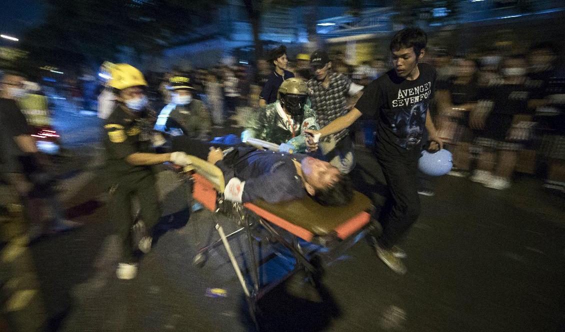 En man som skottskadats i samband med protester i Thailands huvudstad Bangkok förs bort på bår. Foto: Wason Wanichakorn/AP/TT