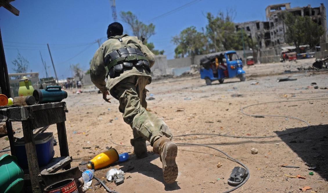 En somalisk soldat försöker skydda sig efter explosioner i Mogadishu i Somalia den 23 mars 2019. Foto: Mohamed Abdiwahab/AFP via Getty Images